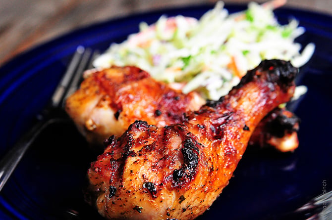 Grilled chicken legs with slaw on a blue plate.