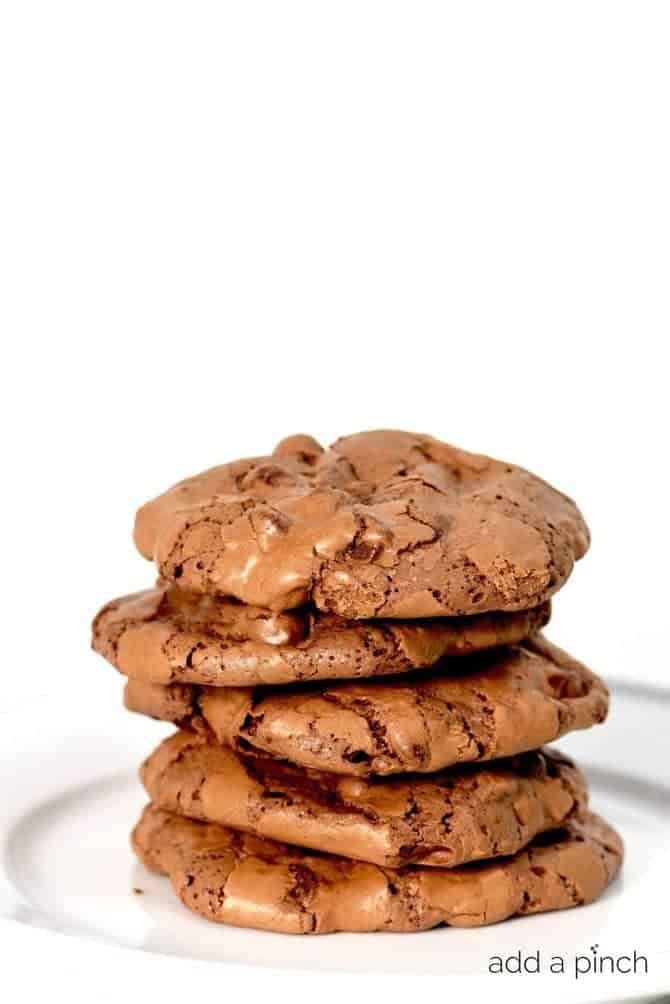 Stack of brownie cookies on white plate.