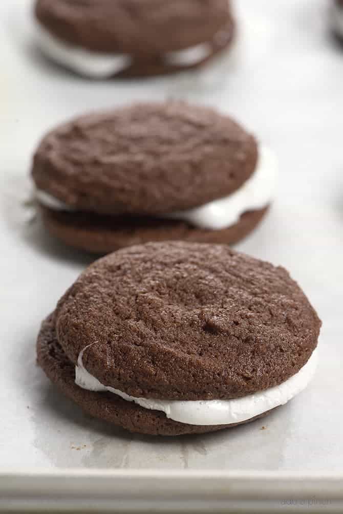 Chocolate cookies have melty marshmallow sandwiched in between them.