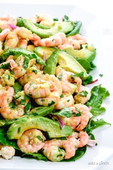 Photograph of Citrus Shrimp Avocado Salad on a white platter on white marble.