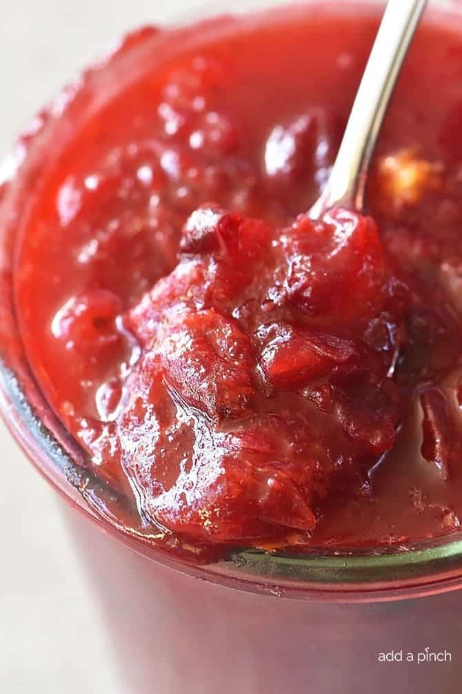 Fresh homemade Cranberry Sauce in glass bowl with spoon.
