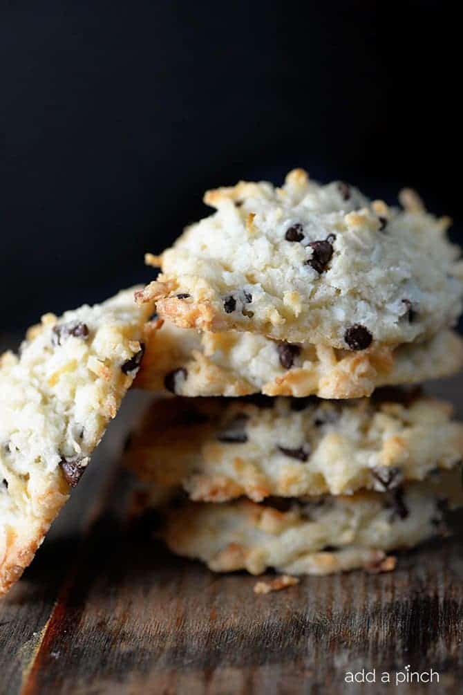 Golden toasted Coconut cookies with mini chocolate chips are served on a wooden board.