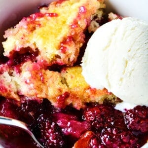 Blackberry cobbler with vanilla ice cream in a white bowl