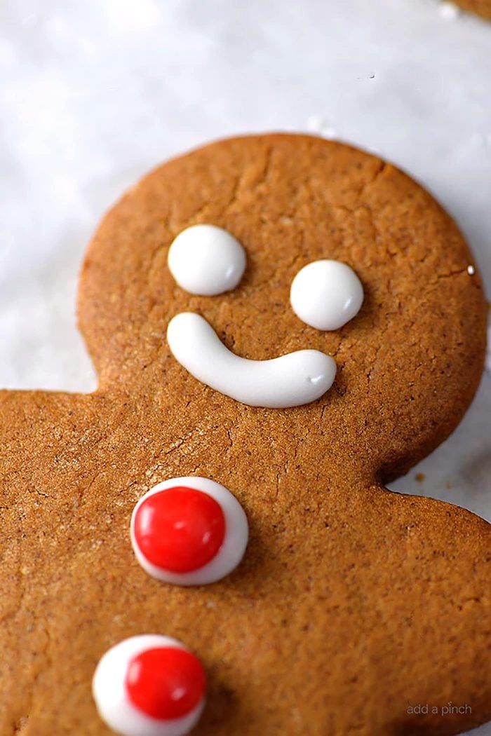 Closeup of a decorated gingerbread man cookie on a marble counter.