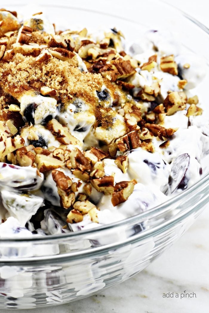 Mixed grape salad topped with nuts and brown sugar.