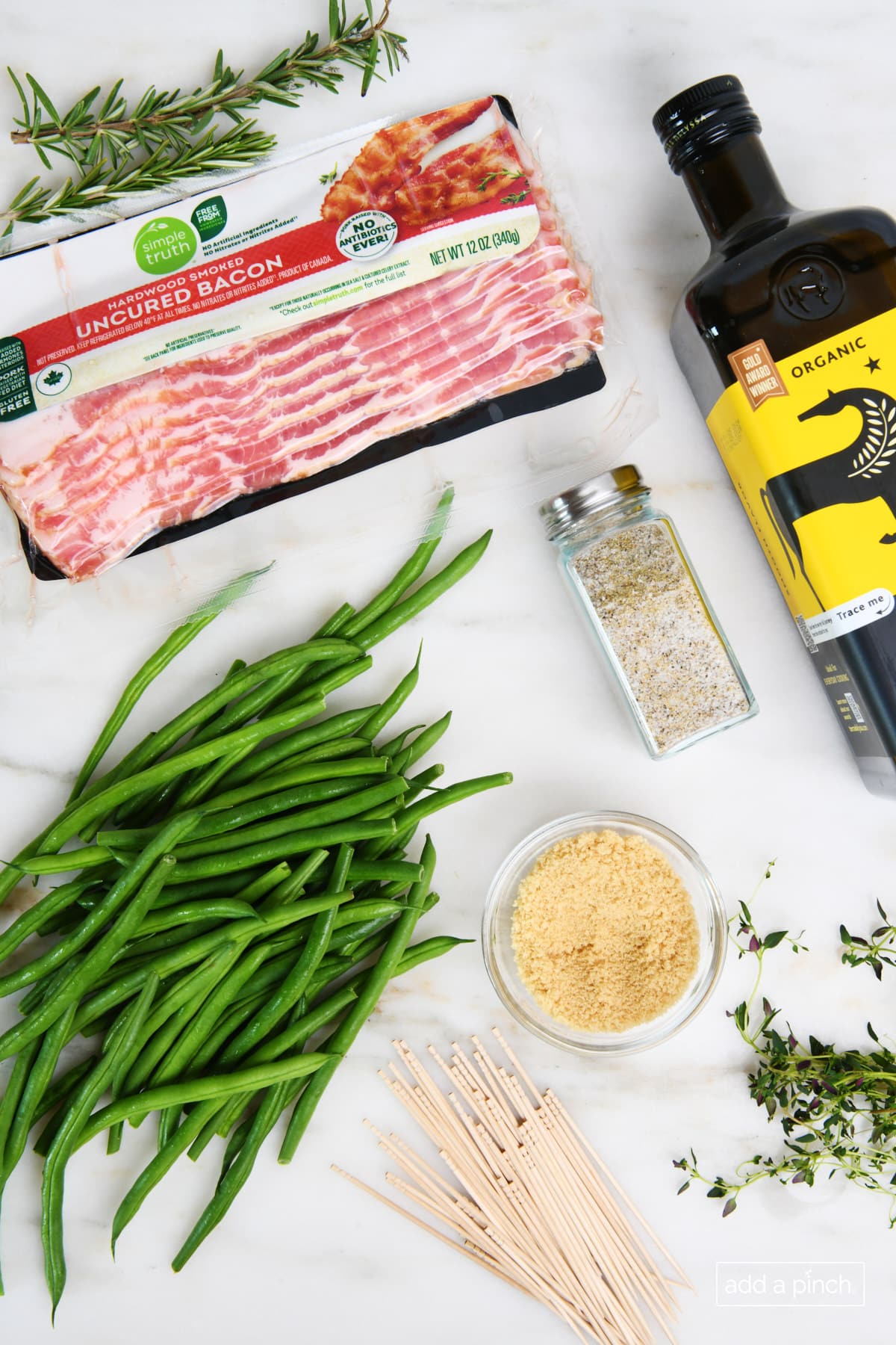 Ingredients on a marble surface to make bacon wrapped green beans.