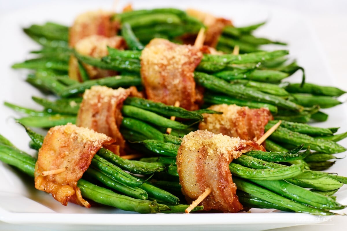 Green bean bundles on a white platter for serving.