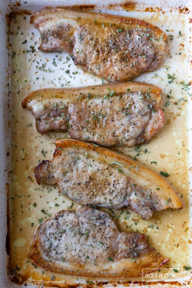 Baked pork chops in a white baking dish