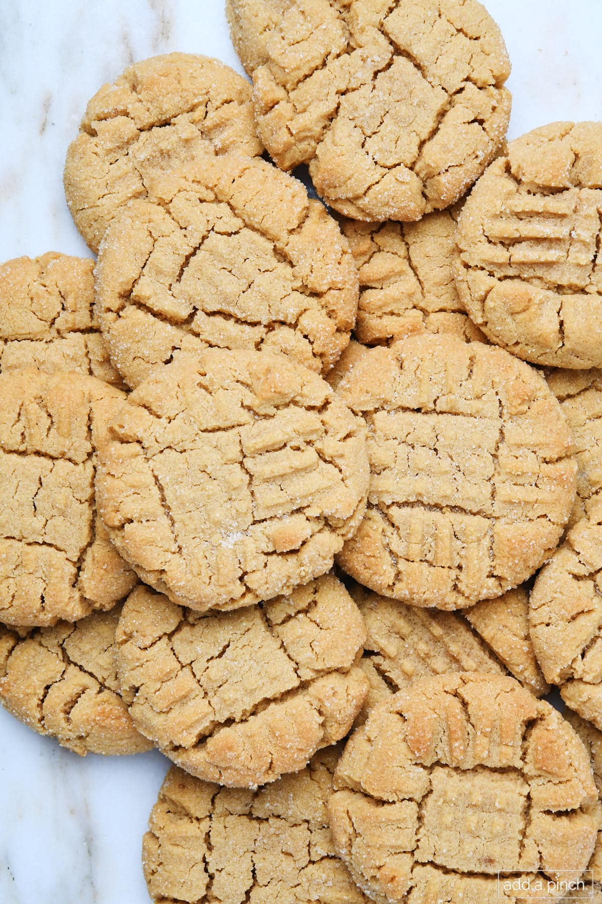 Plate of baked peanut butter cookies with criss cross tops.