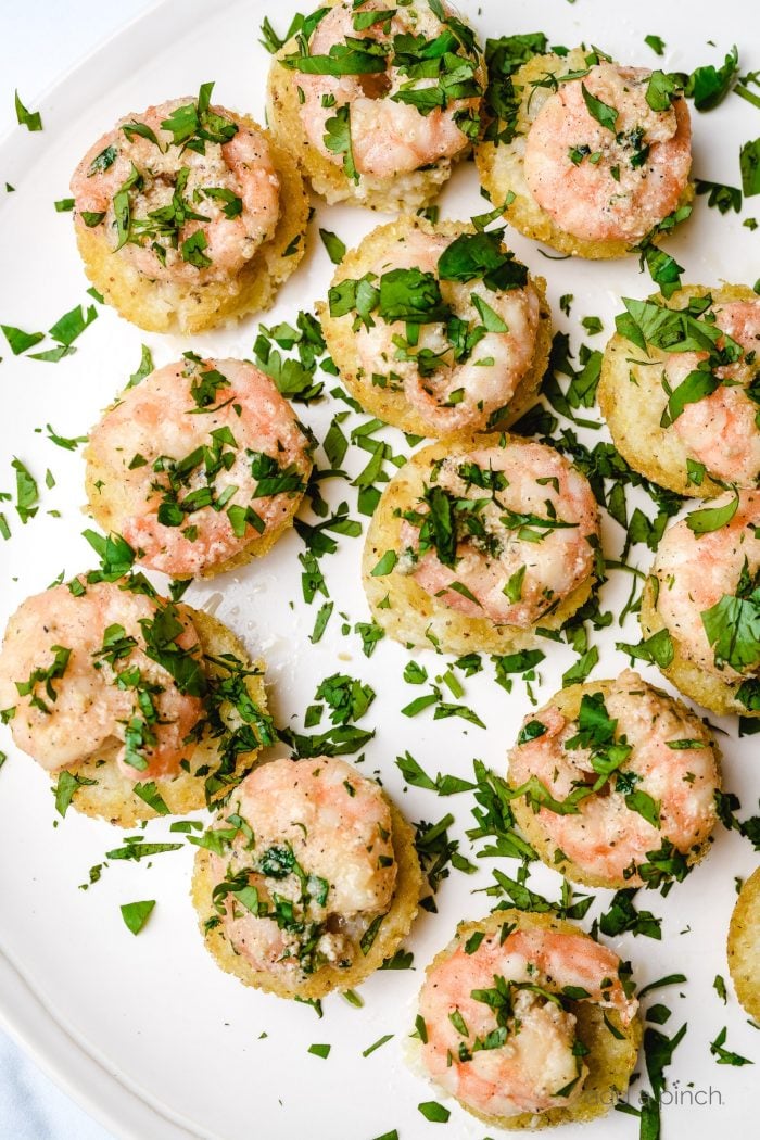 Shrimp and Grits Bites with fresh parsley garnish on a white plate.
