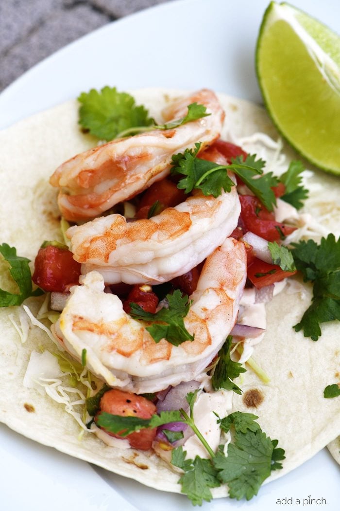 Shrimp Tacos with fresh herbs, cabbage, pico de gallo on a flour tortilla.