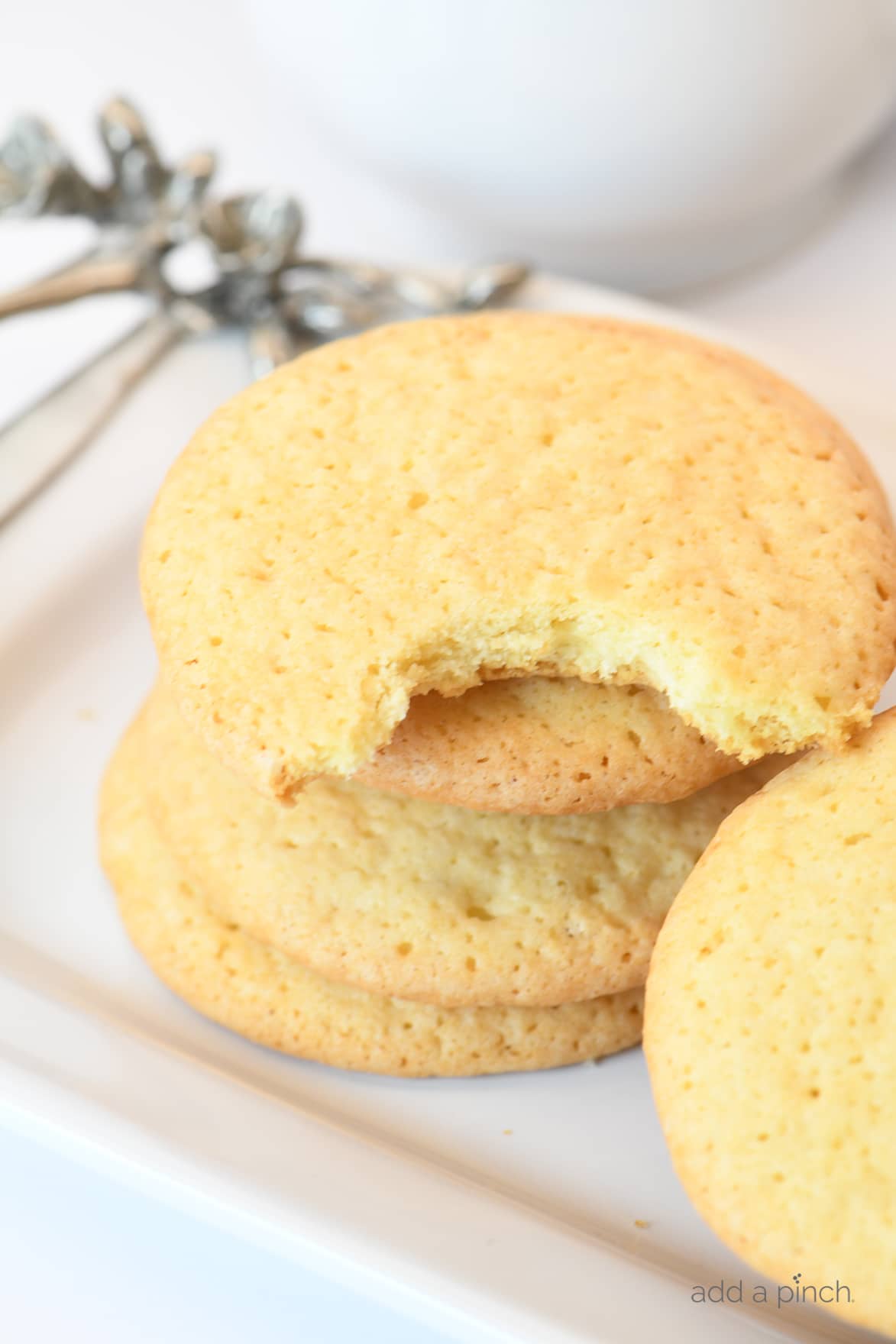 Photograph of tea cakes on a white platter. One tea cake has a bite taken out of it.
