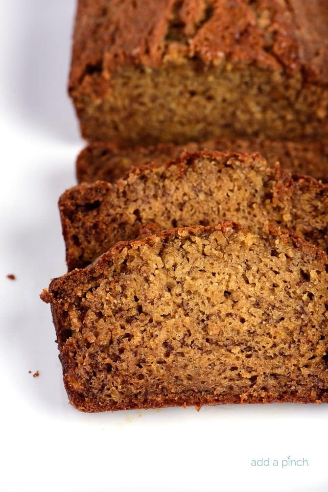 Banana bread that has been sliced on a white platter.