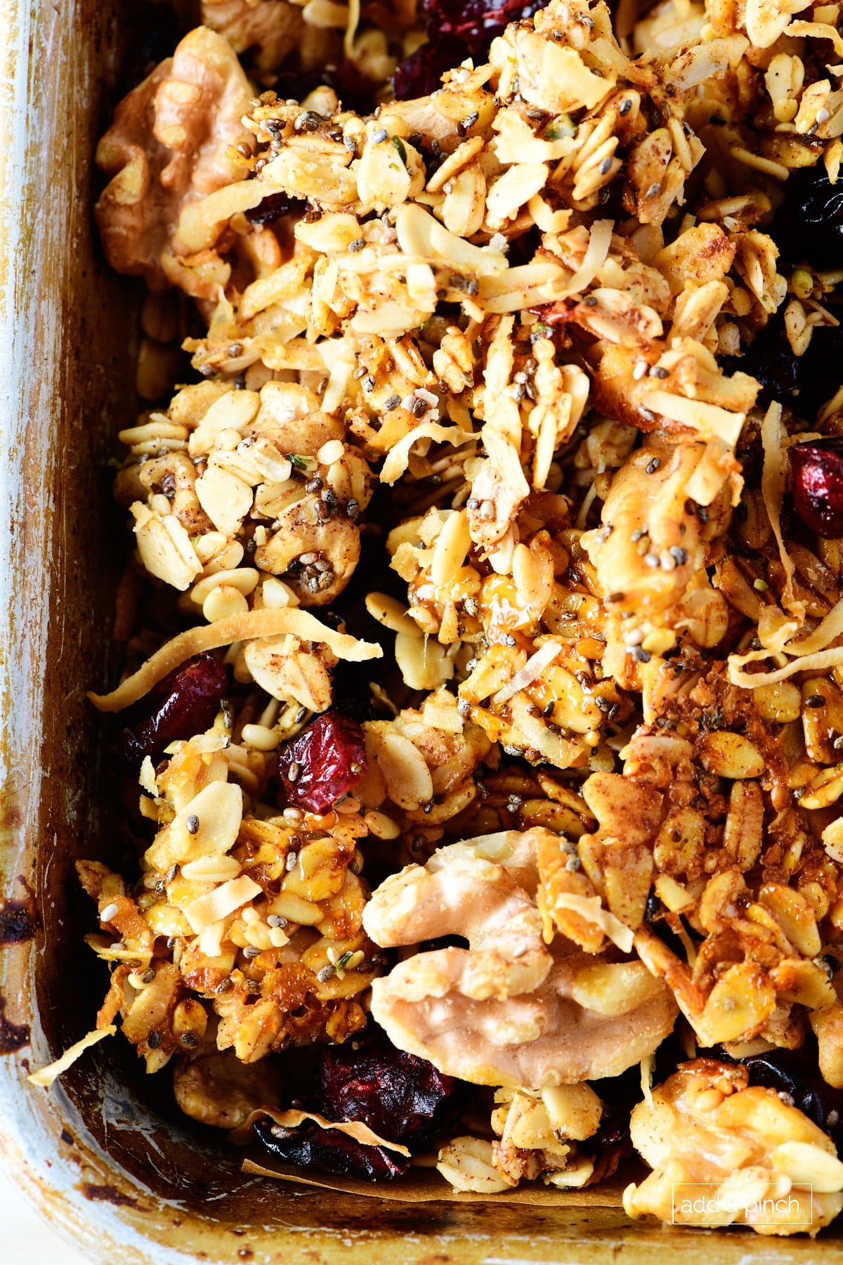 Homemade granola on a baking sheet with a spatula.