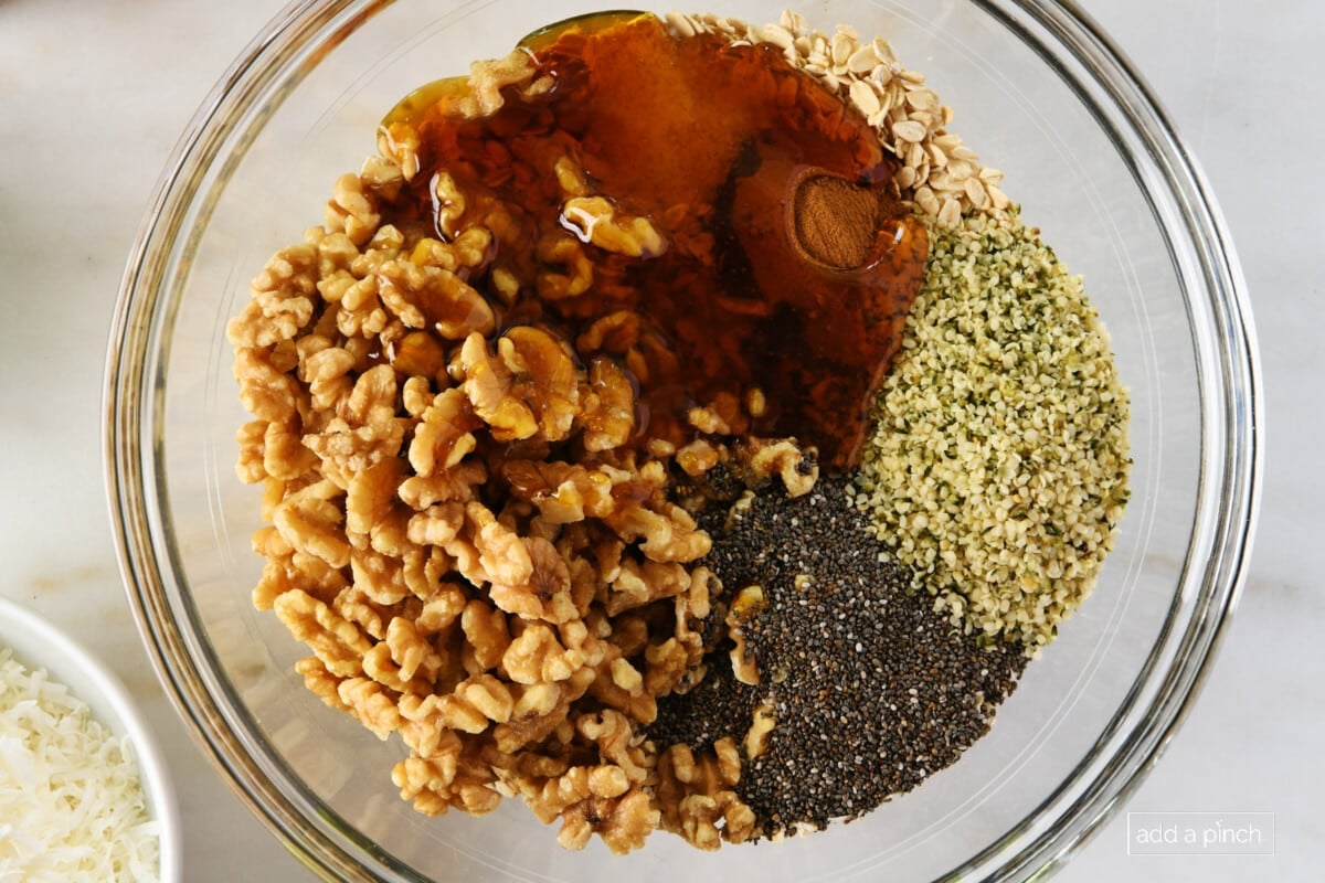 Homemade granola mixture in a glass mixing bowl.